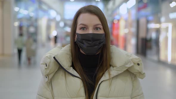 Young Woman Standing and Looking at Camera in Shopping Mall or Trade Center