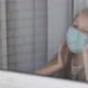 Little girl in a medical mask sad look behind a window in a house. Quarantine Stay home - VideoHive Item for Sale