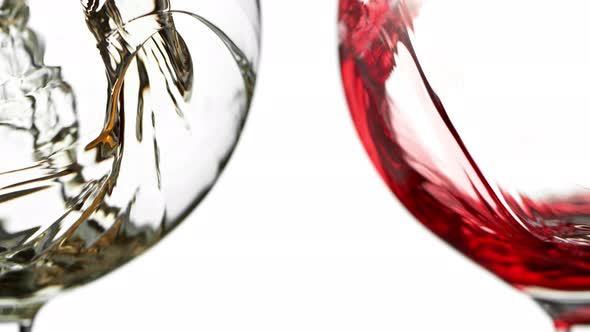 Super Slow Motion Detail Shot of Pouring Red and White Wine Isolated on White Background at 1000Fps.