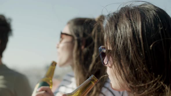 Beautiful Woman in Sunglasses Drinking Beer From Bottle at Party