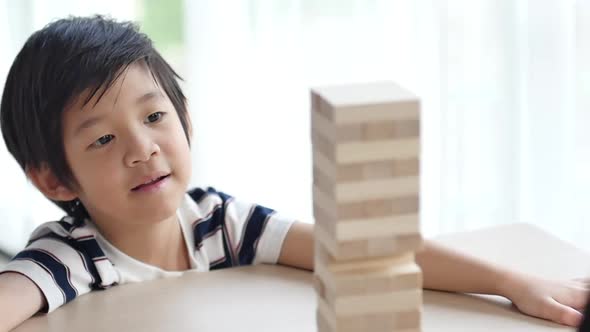 Cute Asian Child Playing Wood Blocks Stack Game