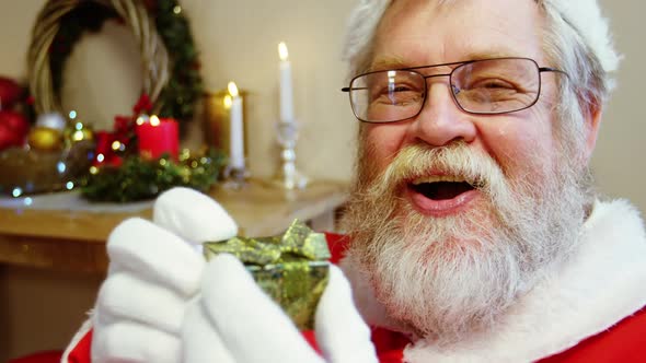 Portrait of santa claus holding gift box