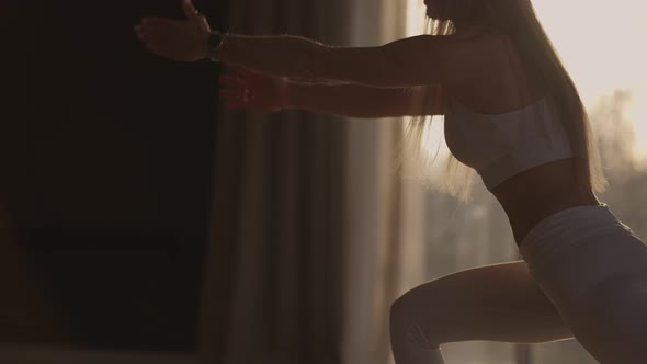 A Young Woman Exercises Performing Exercises From Yoga in Slow Motion in Sunlight