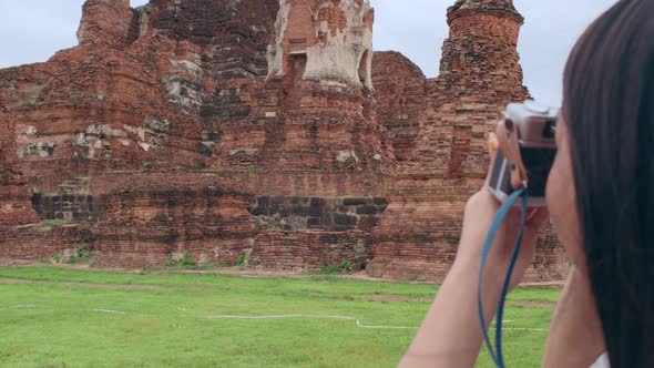 Asian woman using camera for take a picture while spending holiday trip at Ayutthaya, Thailand