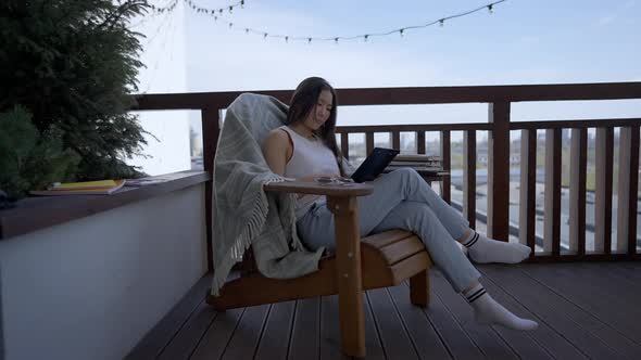 Wide Shot of Confident Slim Woman Analyzing Documents Sitting on Deck in Home Office and Smiling