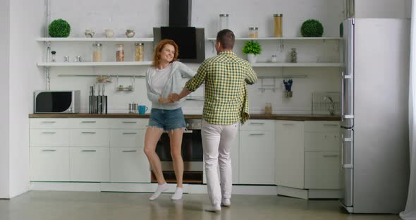 Young Couple Celebrates Weekend Morning, Dancing in Kitchen