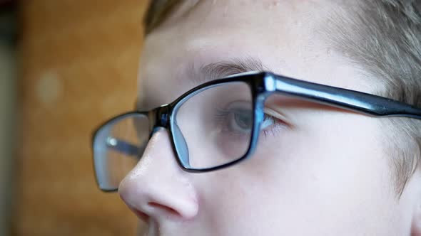 View Front Child with Glasses Looks at Screen of a TV Monitor a PC