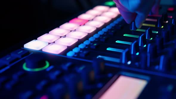 Professional DJ Plays Beat Sampler with Color Drum Pads and Samples in Studio