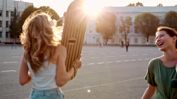 Two Fashion Hipster Girls at Outdoors Summer Party Pretty Teenage Friends with Skateboard in