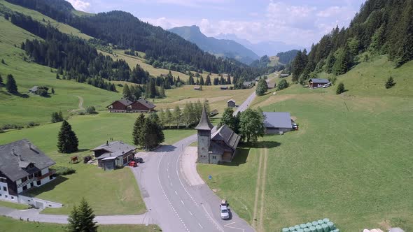 Aerial View of a Valley in Switzerland with Chalets and a Mountainous Landscape