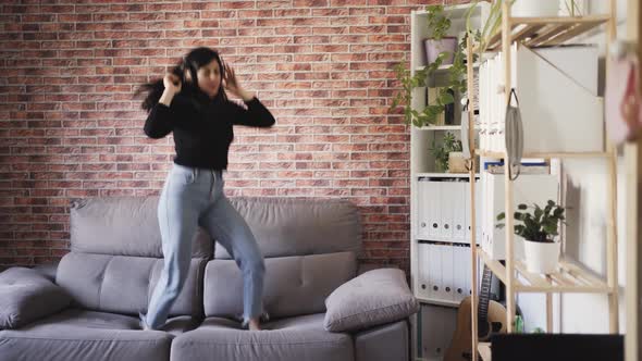 woman dancing on a couch in her house