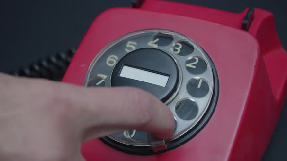 Close-up view of old red rotary phone