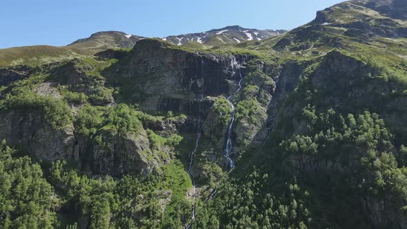 Water Flows Down the Slope of a Mountain Drops Splash From a Huge Rock