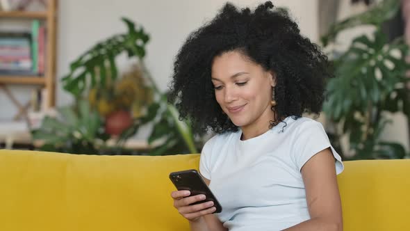 Portrait of a Young African American Woman Texting on Her Phone