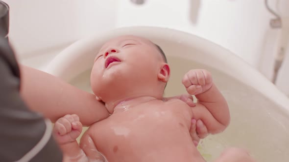 Calm of asian newborn baby bathing in bathtub