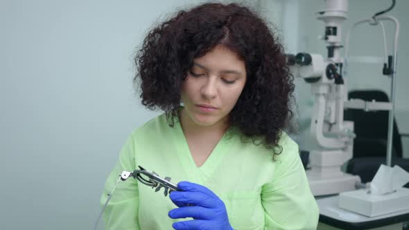 Smart Professional Woman with Optometric Lens Frame and Blurred Autorefractor at Background Smiling