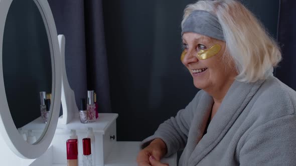 Old Senior Elderly Woman Grandmother Applying Anti-wrinkle Eye Patch, Putting Makeup on at Home