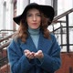 Young Redhead Woman in Blue Coat and Black Hat Throws Sequins - VideoHive Item for Sale