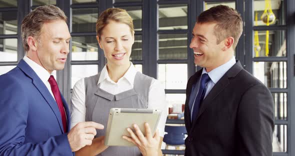 Business people talking together while looking tablet