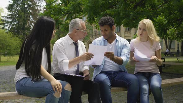 Multi-Ethnic Students Giving Thesis Plans to Their Teacher, Higher Education