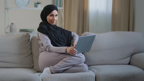 Attractive Young Muslim Woman Wear Hijab Sit on Cozy Sofa in Living Room Adorable Energetic