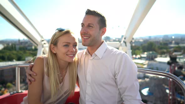 Happy Couple in Ferris Wheel High Above