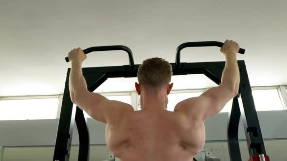 Slow Motion Shot of Male Athlete's Back As He Performs Some Pullup Exercises