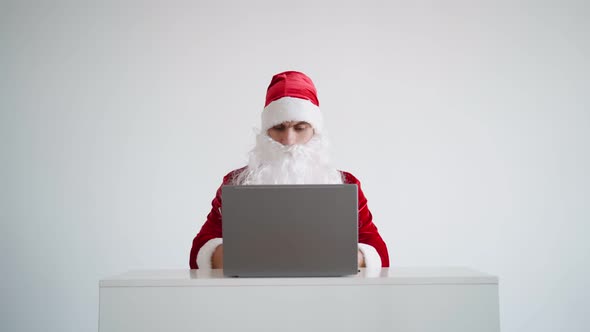 Santa Claus Typing Text on Laptop Keyboard on White Background