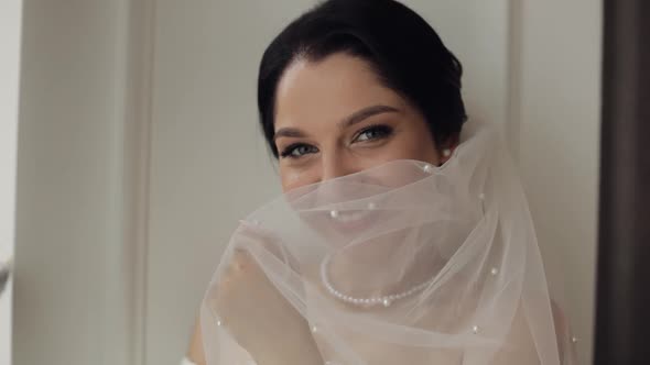 Bride in Boudoir Dress Under Veil and in a Silk Robe Wedding Morning Preparations Before Ceremony