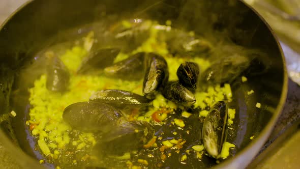 the Cook Cooks Mussels in the Pan