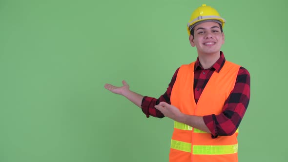 Happy Young Multi Ethnic Man Construction Worker Showing To the Back