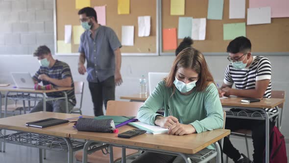 Teenager Wearing Face Mask Learning Writting Assignment at School