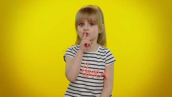 Portrait of Child Girl Presses Index Finger to Lips Makes Silence Gesture Sign Do Not Tells Secret