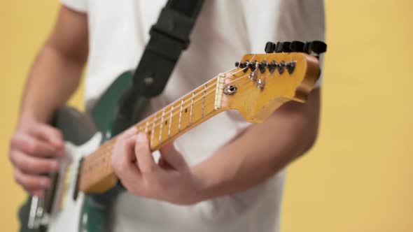 Cropped Blurry Photo of Professional Male Musician in Casual Clothing Playing Electric Guitar Using