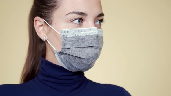 Portrait of Young Woman in Protective Medical Mask Looks Away, Closes Eyes