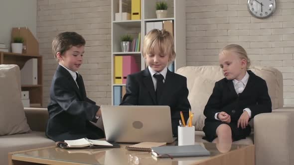 Three Business Children Looking at Laptop