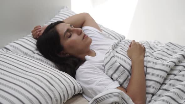 Young Woman Lies in Bed with Closed Eyes, Lady Is Sleeping