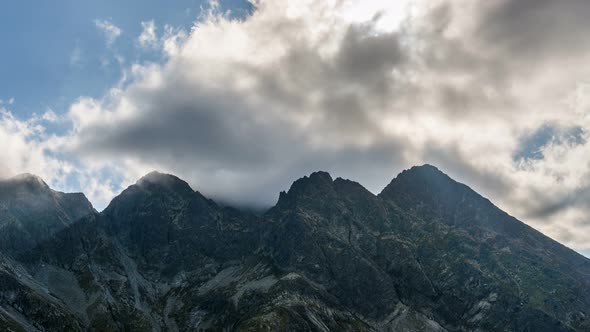 Dramatic Clouds and Sunbeam over Alps Mountains Peak Getting Dark in Sunny Summer