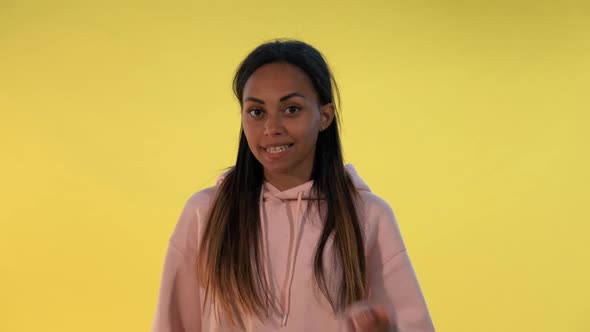 Beautiful Mixed-race Woman Making a Hush Gesture on Yellow Background.