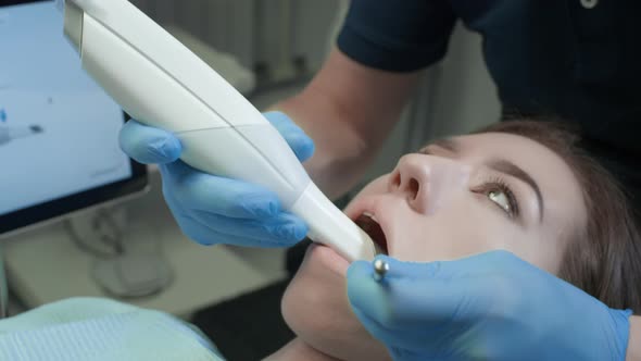 Doctor Scans the Patient's Teeth in the Clinic