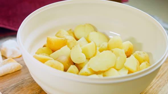 The Chef Cuts the Freshly Boiled Potatoes with a Professional Knife