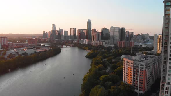 Slow rise from Rainey Street looking downtown at golden hour. Kayaks and paddle boarders can be seen