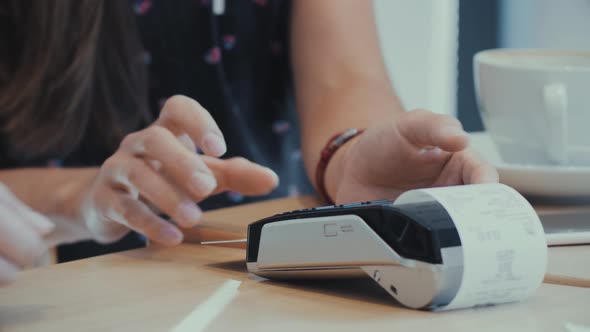 Person paying in cafe with a credit card