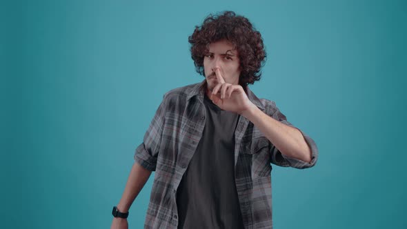 Young Hipster Touches His Nose with His Finger