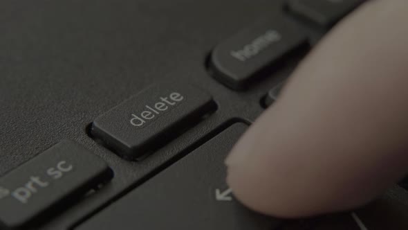 Finger Presses Delete Button on Keyboard
