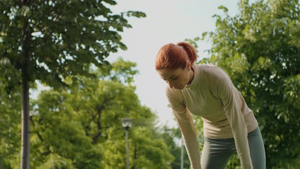 Woman stops from jogging and making short break to breath.