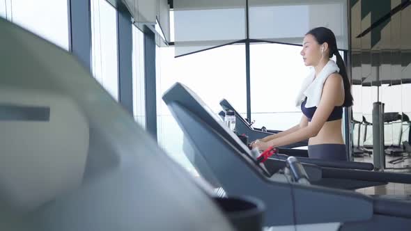 slow motion beautiful asian Sport women walk cool down on treadmill cardio equipment gym background