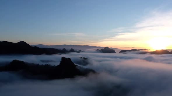 Slow motion of landscape of mountains and hills with the sea of fog before sunset.