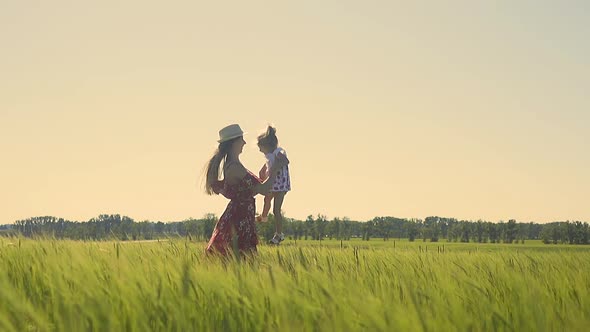 Slow Motion Young Mother Throws Little Daughter in Her Arms