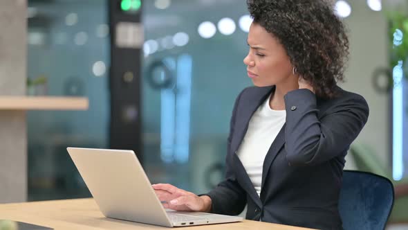 Tired African Businesswoman with Laptop Having Neck Pain at Work